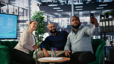 Diverse business leaders finishing their meeting and taking photos, ensuring their presence on social media platform and marking the beginning of a fruitful corporate partnership.の写真素材