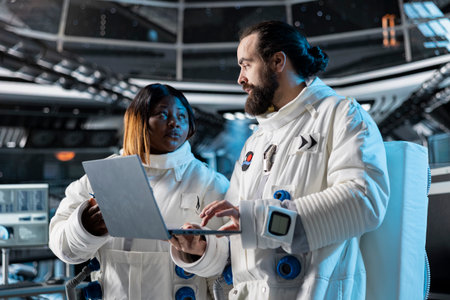 Researchers in space conducting scientific experiments in orbit using laptop. Scientists using...