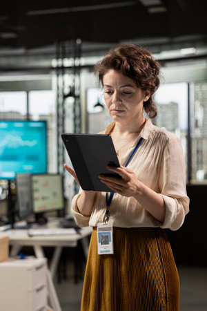 Professional workspace where focused employee developing business solutions with tablet, combines strategy planning and performance metrics analysis for new goals achievement.の写真素材