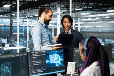Programmers working together, coding in data center, updating deep learning scripts. Asian man and...