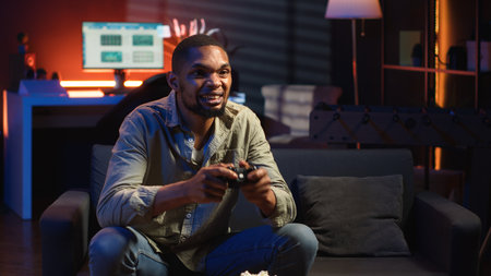 African american angry player being frustrated about his lost competition, losing the video games online tournament in his living room. Mad irritated person with a gaming failure. Camera B.の写真素材