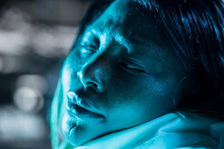 Sick female astronaut lies still in cold spaceship chamber after temperature control failure causes severe heat loss. Woman freezing in orbital station after conditions drop below survival limitの写真素材