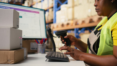 African american staff scanning awb labels after packaging tasks in a distribution hub, using a...