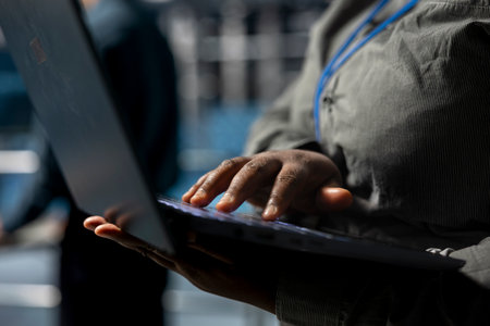 Close up of system administrator in data center analyzing infrastructure performance outputs on...