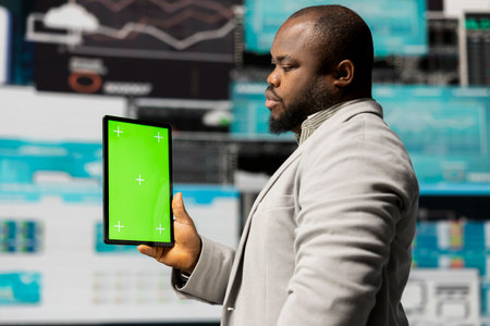 African american businessman using isolated mockup on gadget, reviewing big data insights on dashboard. Young adult showcasing strategic decision making, productivity and growth.の写真素材