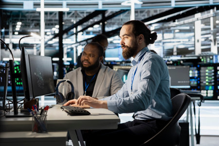 Team of programmers using computer in server farm, analyzing data. Men working in data center office...
