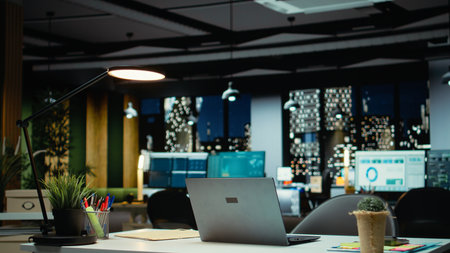 Modern business workspace glows with forecasting metrics and graphs. Corporate empty space equipped with technology and computers reflects administration of enterprise objectives.の写真素材