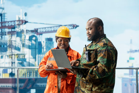 Soldier doing escort duty for offshore platform vessels and engineering crew. Naval unit safeguarding drilling rig infrastructure against terrorist threats, supervising operations with workerの写真素材