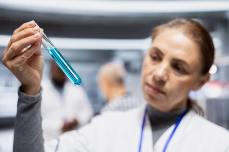 Female expert checking DNA chemical matter in test tubes for color change during laboratory testing procedure for new drug. Biotechnology innovation, clinical research and medicine progress.の写真素材