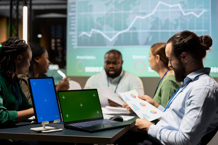 Diverse experts group gather for a corporate event with isolated display after hours, aligning...