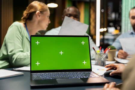 Workers group reviewing insights with chroma key after hours, analyzing annual trends and collaborating on project agenda supported by visual data. Business intel projections in a meeting.の写真素材