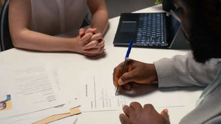 Close up of a man signing work contract with human resources manager, joining the company after...