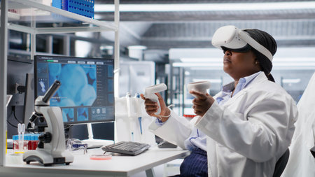 Black woman using VR headset to explore 3D interactive experiment in laboratory, biochemistry and nanotechnology study. Expert uses virtual reality glasses and gadgets for science.の写真素材