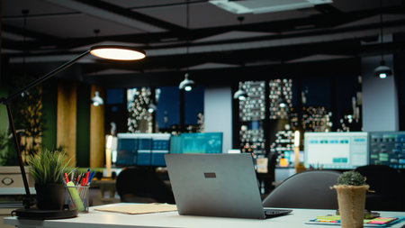 High end empty office features laptop and monitors for forecasting. Modern space set for corporate planning, analytics and performance indicators that drive organizational success.の写真素材