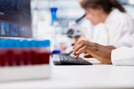 Close up of laboratory researcher using computer software to process DNA patient data for clinical research. Lab specialist typing on PC keyboard, doing genetic analysis diagnosticsの写真素材