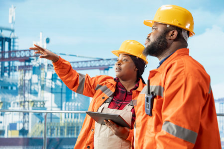 Offshore platform engineers monitoring environmental impact with tablet app, ensuring sustainable drilling. Drilling ship employees working together, taking marine ecosystem protection measuresの写真素材