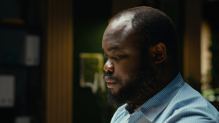 Drained restless male worker being sleepy late at night in the office, going into mental haze and exhaustion due to intense workload. Man in discomfort feeling anxious and tensed.の写真素材