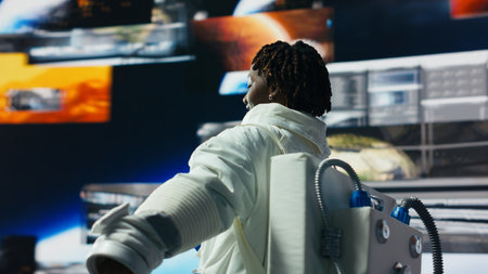 Cheerful astronaut dancing while surrounded by Mars planetary data on displays in spacecraft. Jolly...