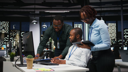 African american staff members consulting each other for monthly reports, reviewing KPI data...