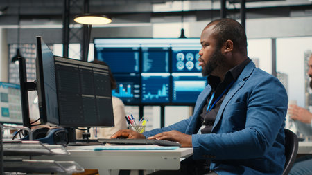 African american male analyzing financial data forecast on a computer, developing innovative...