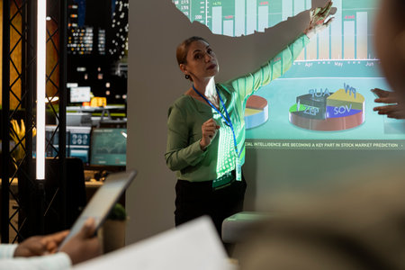 General director showing statistics data on projection board in a conference, overview meeting with specialists for a presentation. Workmates studying reports to adapt within market conditions.の写真素材