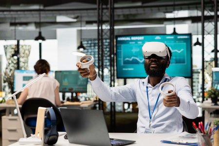 Black man in office exploring data analysis and financial evaluations with VR headset. African american corporate worker using virtual reality technology during innovative business project planningの写真素材
