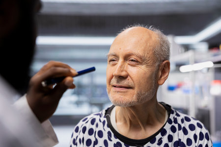 Close up of medic observes patient reactions during a drug trial with light pen in a healthcare institute, recording data and monitoring vitals to ensure safe dosage levels for progress in medicine.の写真素材