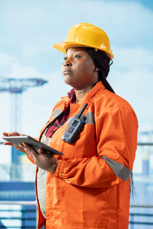 Offshore platform engineer uses monitoring app on tablet to track emissions and environmental performance. Expert conducting environmental risk assessment for drilling rig sitesの写真素材