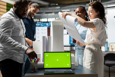 Property developers team reviewing blueprints next to copy space display, collaborating on new urban development residential project through city planning and design. Smart city.の写真素材