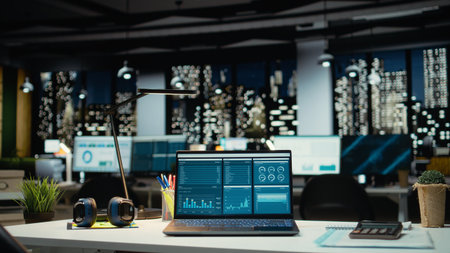 Modern laptop showcasing data reports in an empty office late at night, performance metrics and forecasting graphs. Corporate workspace equipped with technology to reflect business management.の写真素材