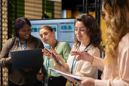 Women associates collaborating over performance metrics for a new financial strategy in a...