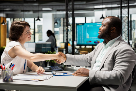 Confident male candidate receives a warm welcome from the HR manager after being accepted, both...