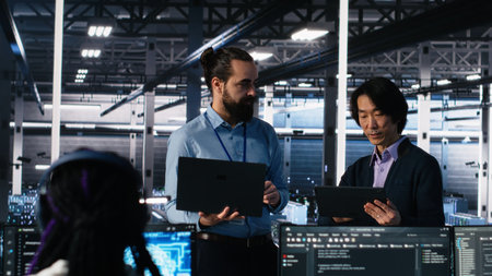 Data center manager supervising work done by programmers working on neural network software. Server hub supervisor overseeing IT staff members implementing deep learning tech, camera Aの写真素材