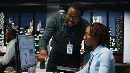 Black team of business colleagues analyzing data insights on desktop pc in office, consulting the analysis forecast before developing a new strategy for the enterprise activity.の写真素材
