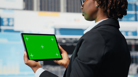 Green screen tablet used by business specialist to review performance dashboards metrics. Management executive evaluating annual report data using chroma key device app, close upの写真素材