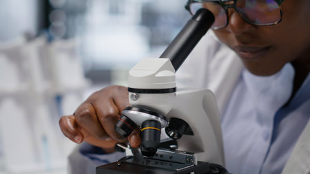 Microscope close up of glass tray under the lens for cellular analysis, expert studying molecular and genetics specimen. DNA sample optics with advanced equipment for biochemistry.の写真素材
