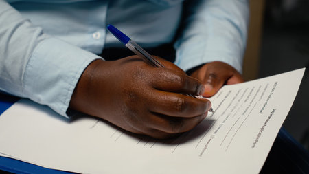 Close up of candidate filling in registration forms for job application and interview, ensuring a great recruitment process and successful meeting with the HR. Writes down qualifications.の写真素材