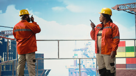 Drilling barge engineers use two way radio to communicate with logistics crew, monitoring systems. Offshore platform team talking in walkie talkie, controlling operation,の写真素材