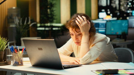Business employee leaning on her desk showing symptoms of burnout syndrome. Sleep deprivation and...