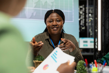 African american finance analyst shows data analytics in briefing meeting, presenting the business situation with the investors group. Woman CEO discuss changes with shareholders.の写真素材