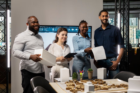 Portrait of real estate developers team planning a high density housing project, attention to sustainability and urban infrastructure growth. Blueprints for residential master plan.の写真素材