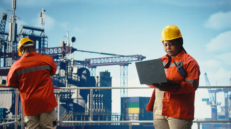 Portrait of smiling offshore platform engineer using monitoring app to track pollution data. Happy woman conducts environmental risk assessment for drilling rig site using notebook,の写真素材