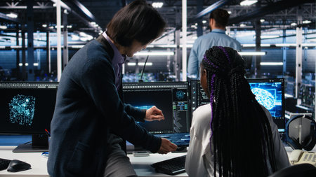 Multiracial technicians in diverse data center review AI diagnostics, analyzing neural network...
