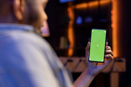 Confident male freelancer utilizing isolated copy space in the living room, laying on his sofa in a modern living room decorated with neon lights and trendy furniture.の写真素材