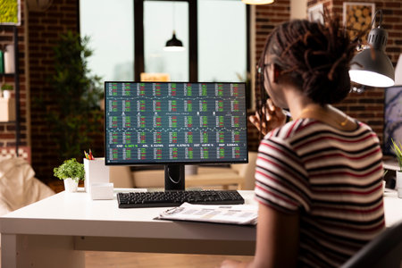 Black female freelancer focused on monitoring stock market performance and company financial growth...