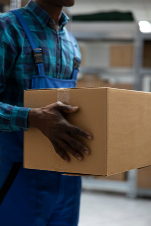 Manual labor tasks in industrial warehouse involve checking shipments, handling parcels and organizing supply packages to support distribution and inventory process.の写真素材