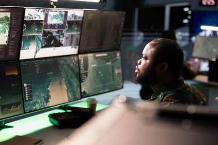 Army operative in command center analyzing surveillance data during global warfare. Intelligence...