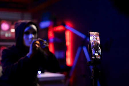Close up of mobile phone used by hacker concealing identity filming ransom video in hidden...