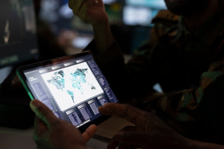Military officer using tablet device to deploy electronic warfare tools to disrupt enemy...