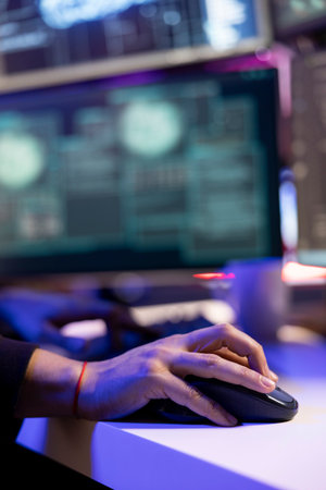 Close up of hacker in secret hideout stealing sensitive information using VPN on dark web. Rogue software developer using computer, breaking into systems to take restricted dataの写真素材